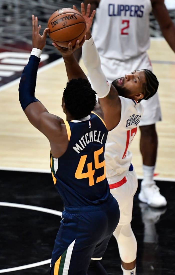 Donovan Mitchell (45) scores over Paul George (13) and the Los Angeles Clippers